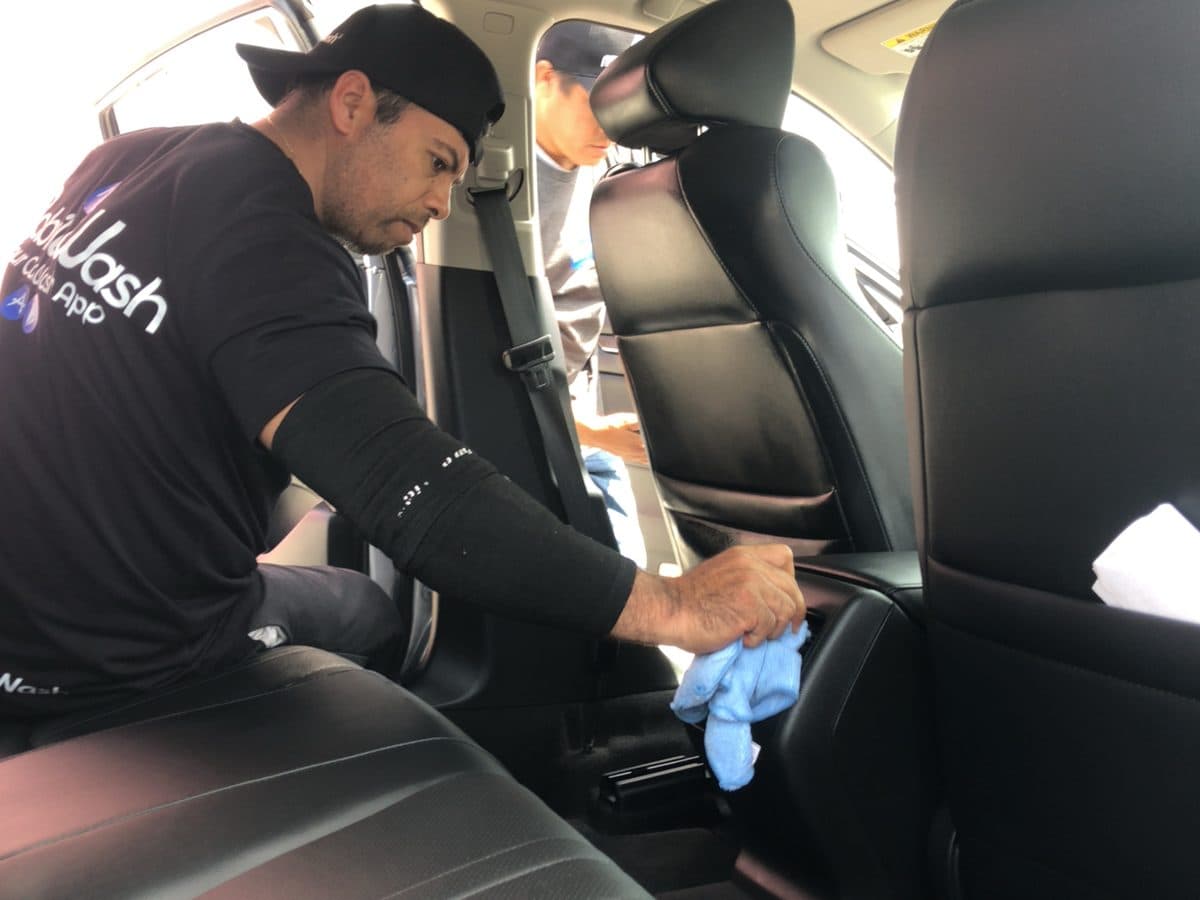 Detailer wiping down a leather rear seat