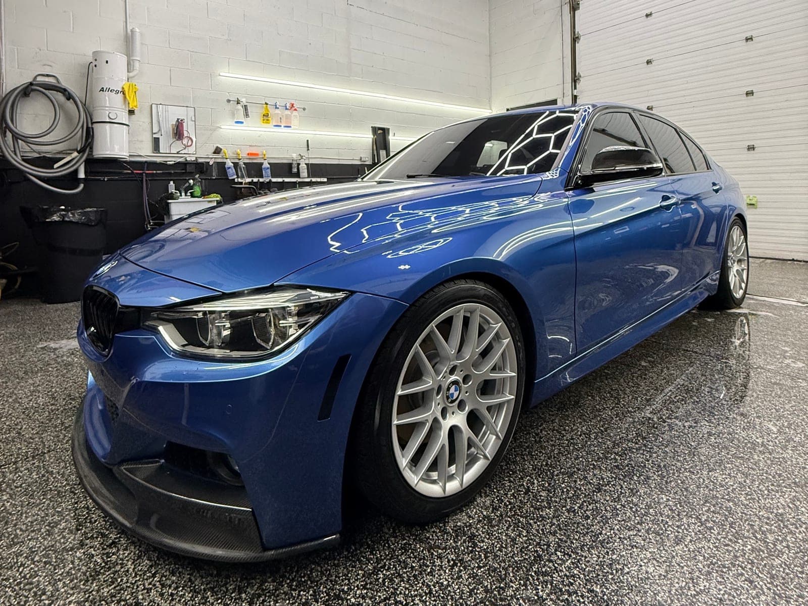 Estoril Blue BMW F30 M Sport sedan freshly detailed under hexagon shop lights