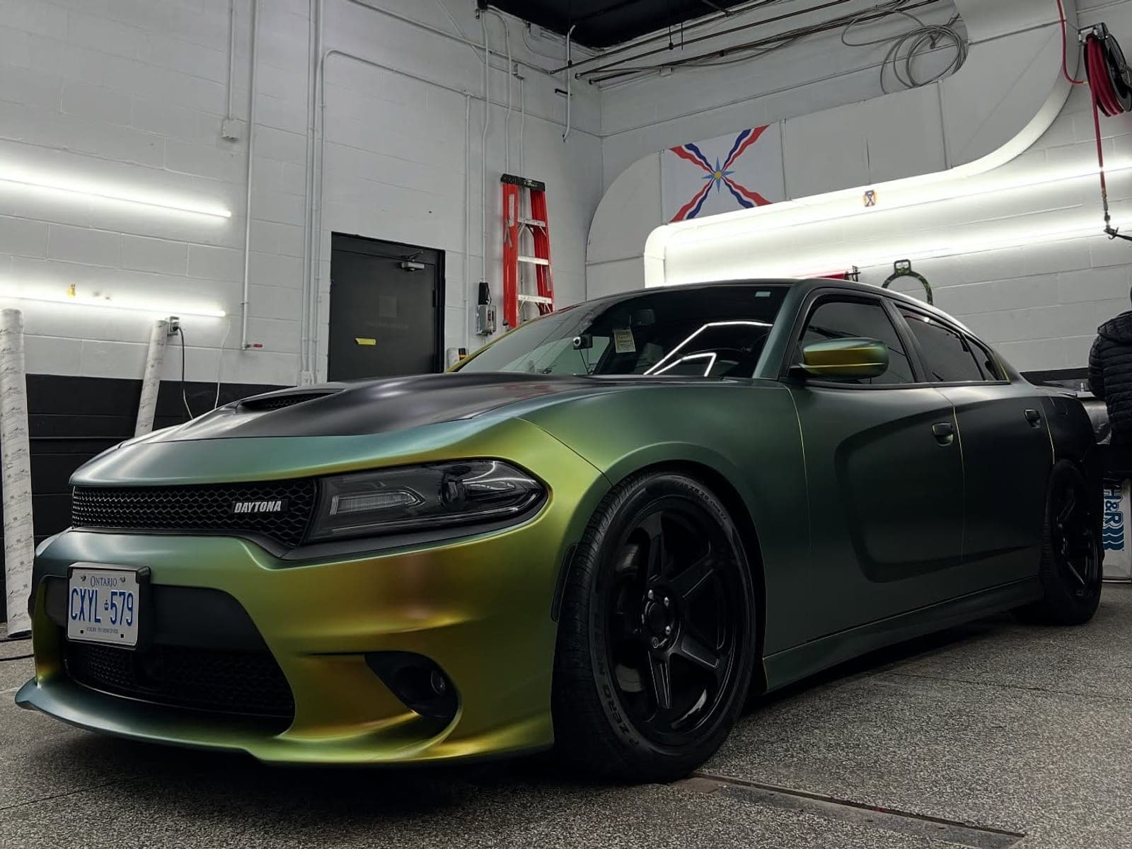 Dodge Charger Daytona in a green-gold satin wrap with a satin black roof