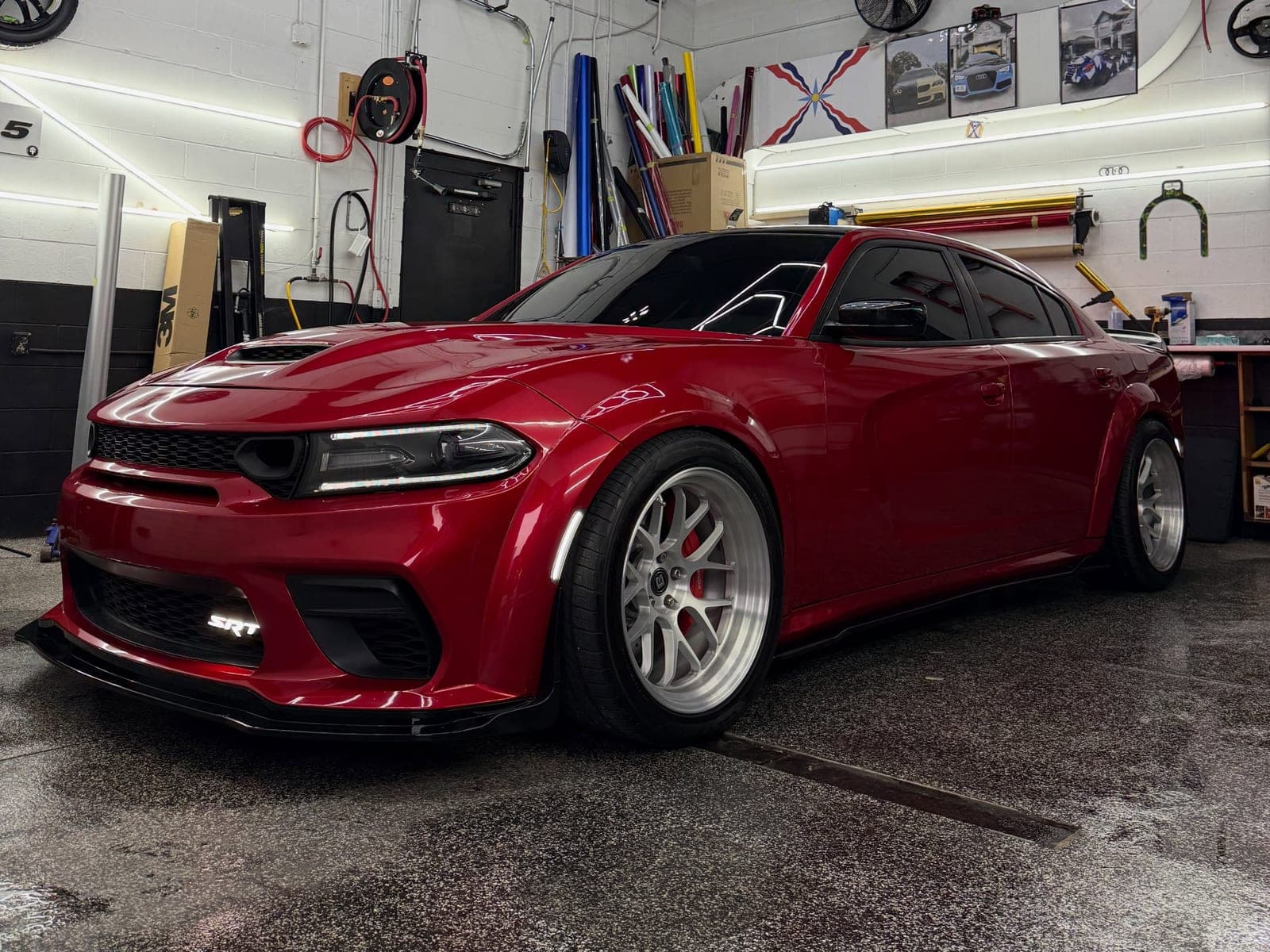 Gloss red Dodge Charger SRT Widebody with silver wheels under the shop lights