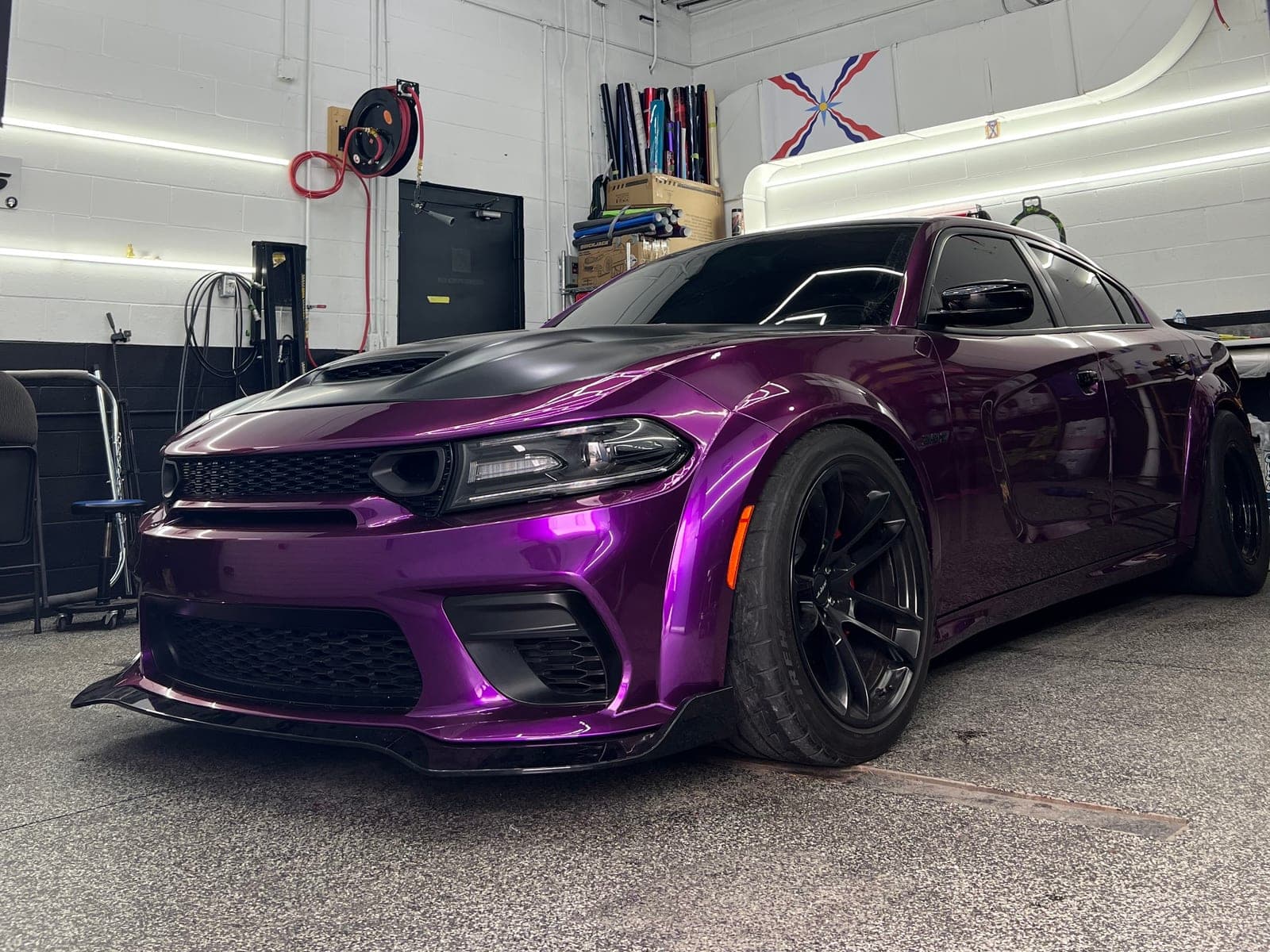 Gloss metallic purple Dodge Charger Widebody with a satin black hood under hexagon shop lights