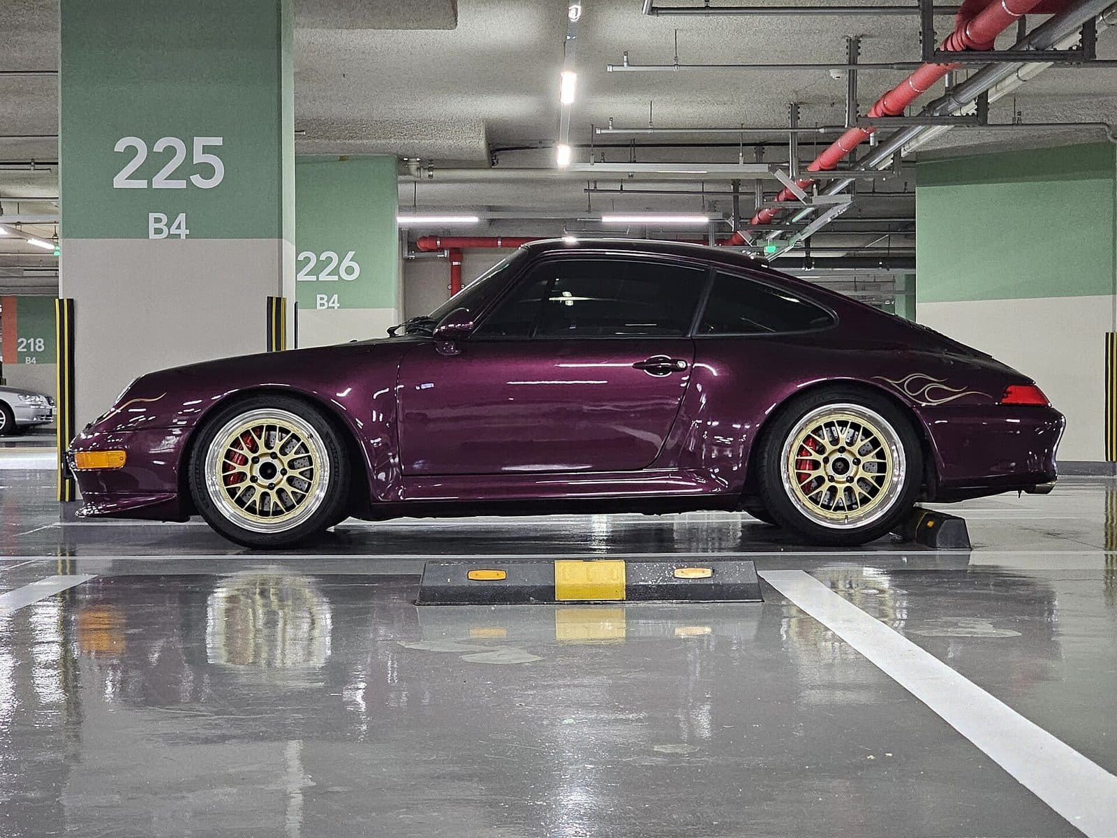 Deep purple Porsche 911 in an underground garage